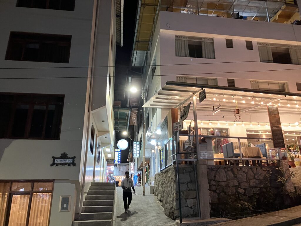 Av. Hermanos Ayarの街路名表示とBUS TICKETの案内看板がある脇道